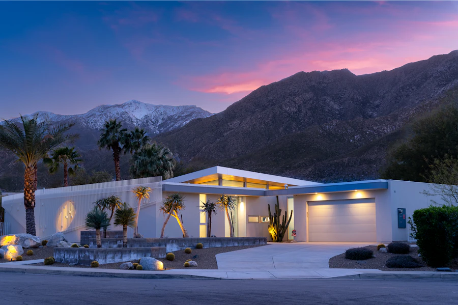 Contemporary single-story home at dusk beneath a mountain ridge