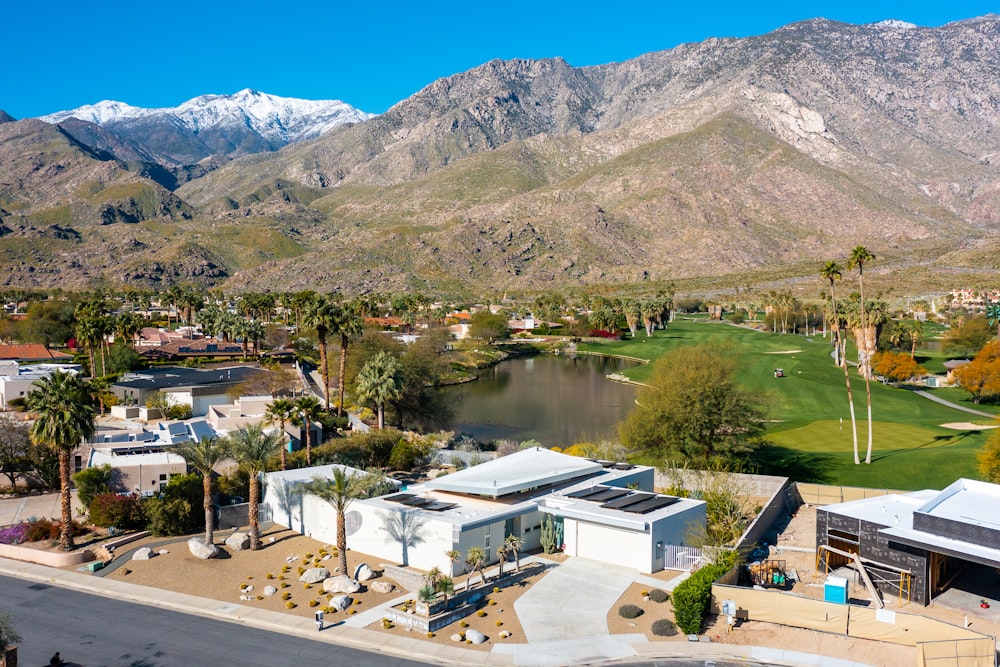 an aerial view of a golf course with mountains in the background