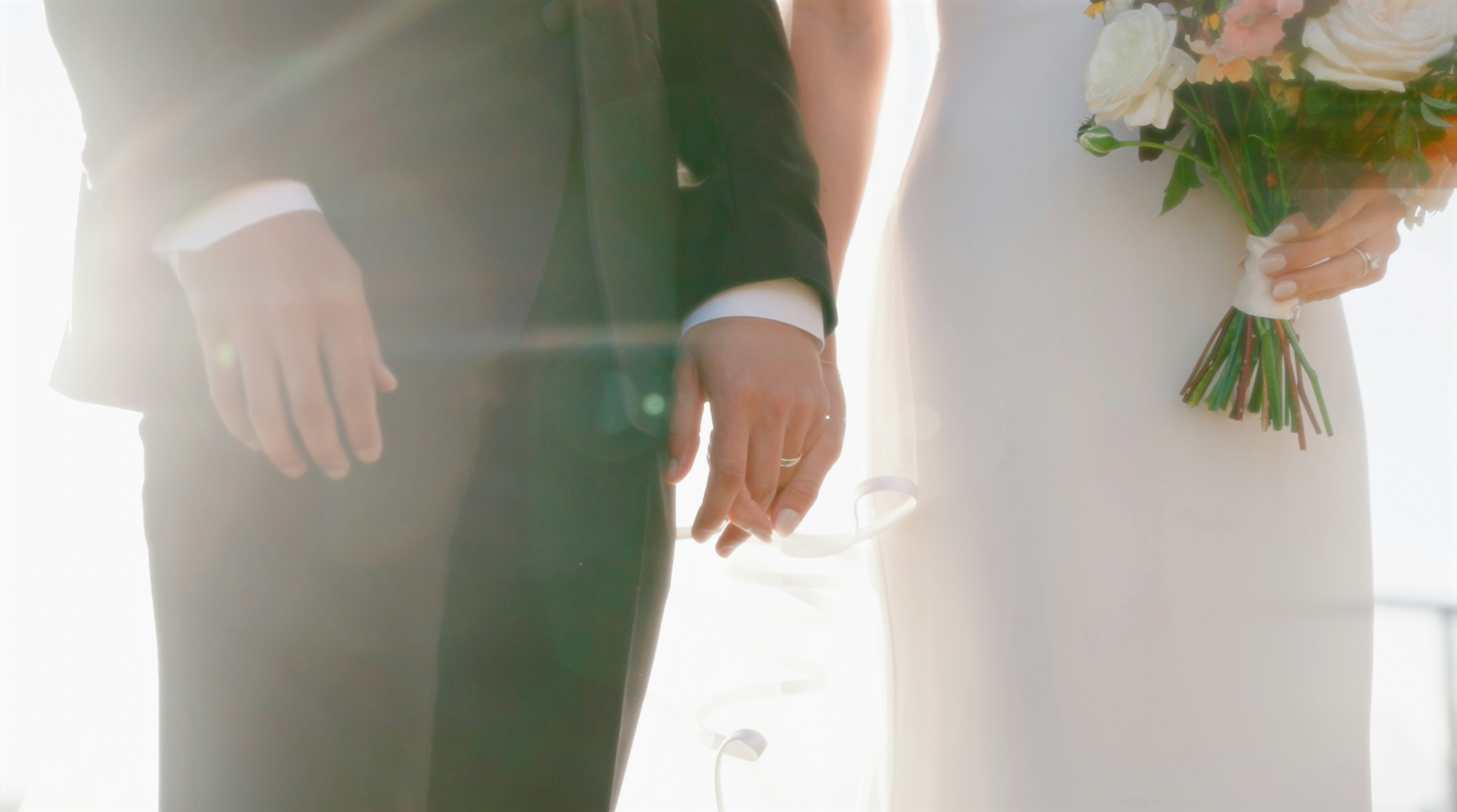 happy couple holding hands, showing their wedding bands - wedding band appraisal