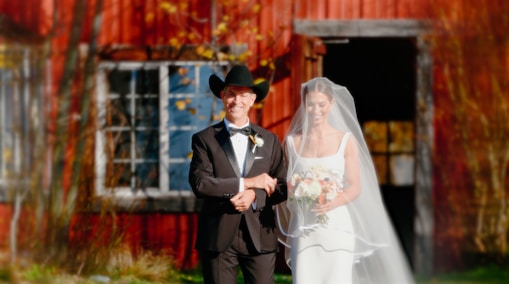 a bride and groom standing in front of a barn