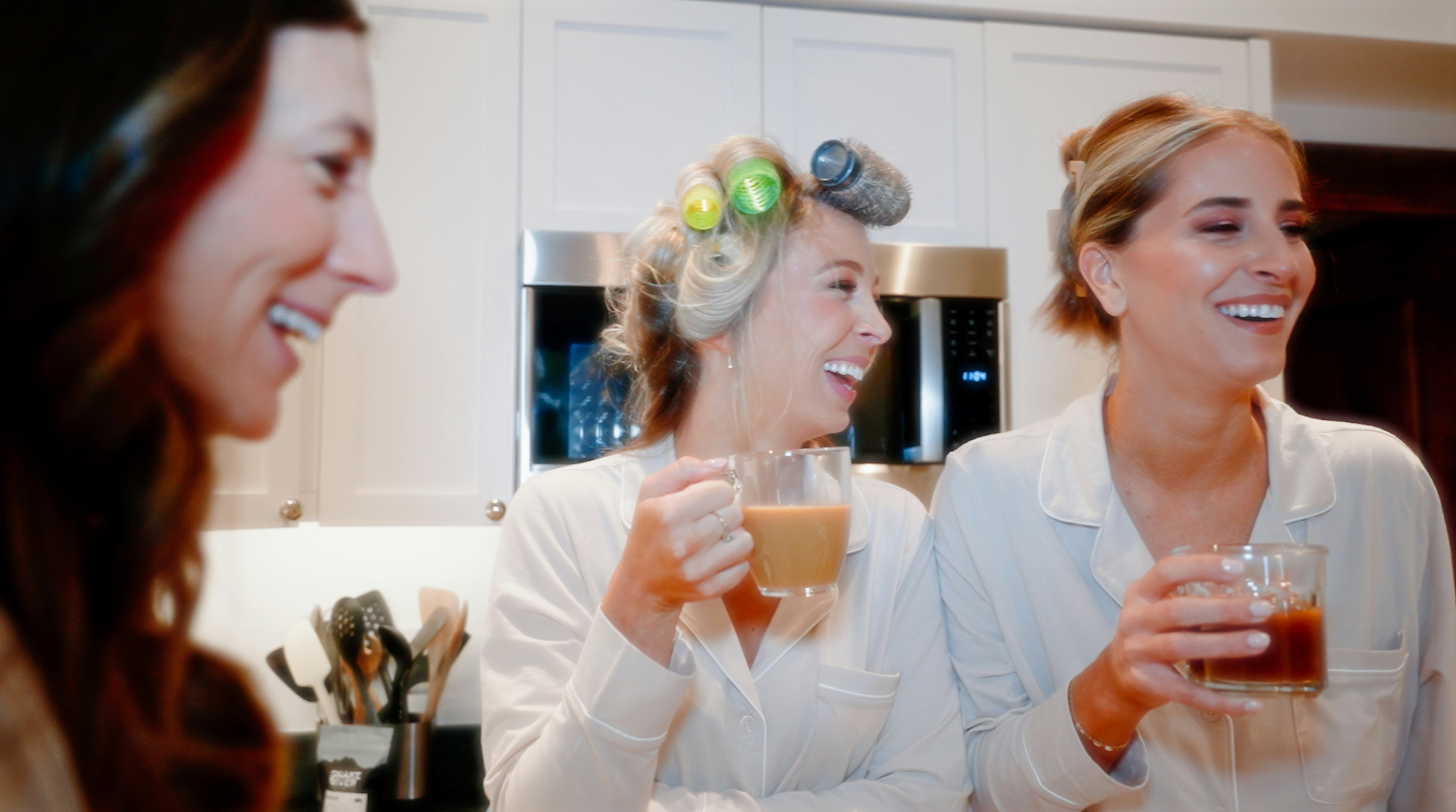 a group of women standing next to each other holding drinks