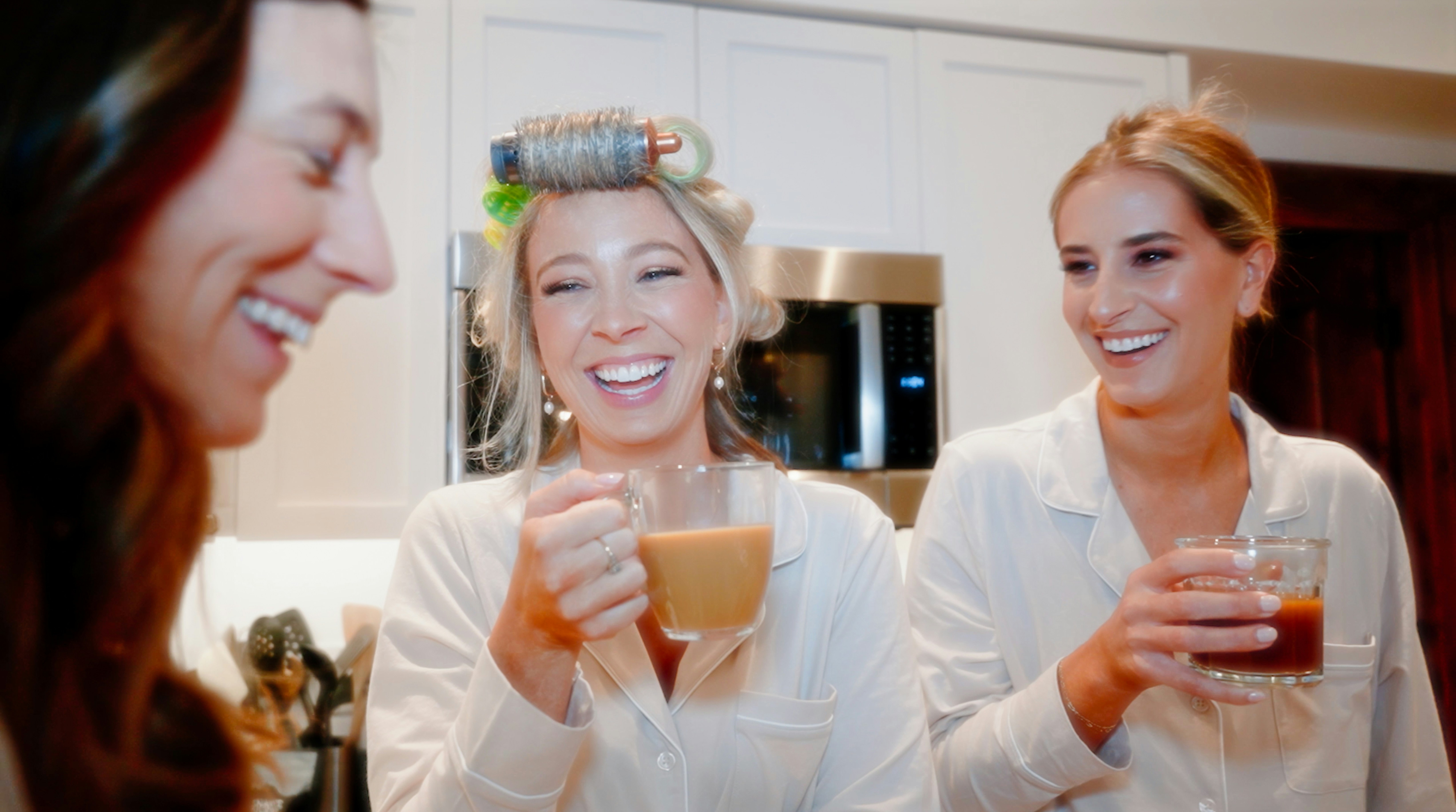 a group of women standing next to each other holding drinks