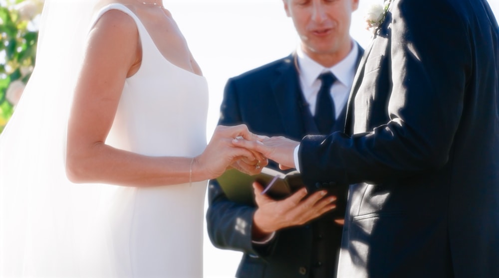 a man and a woman holding hands during a wedding ceremony