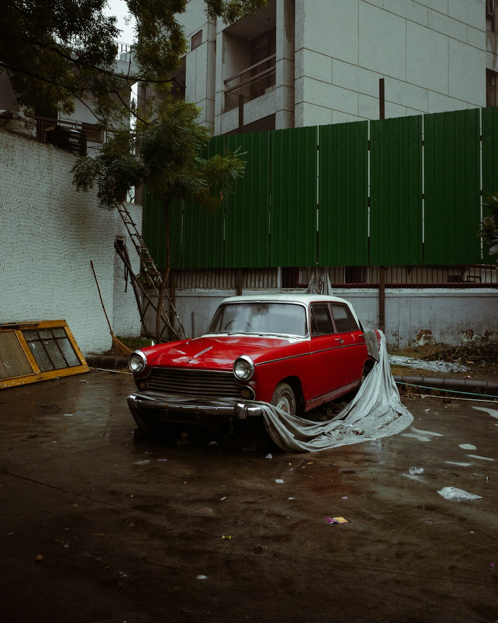 a red car parked in a parking lot next to a building