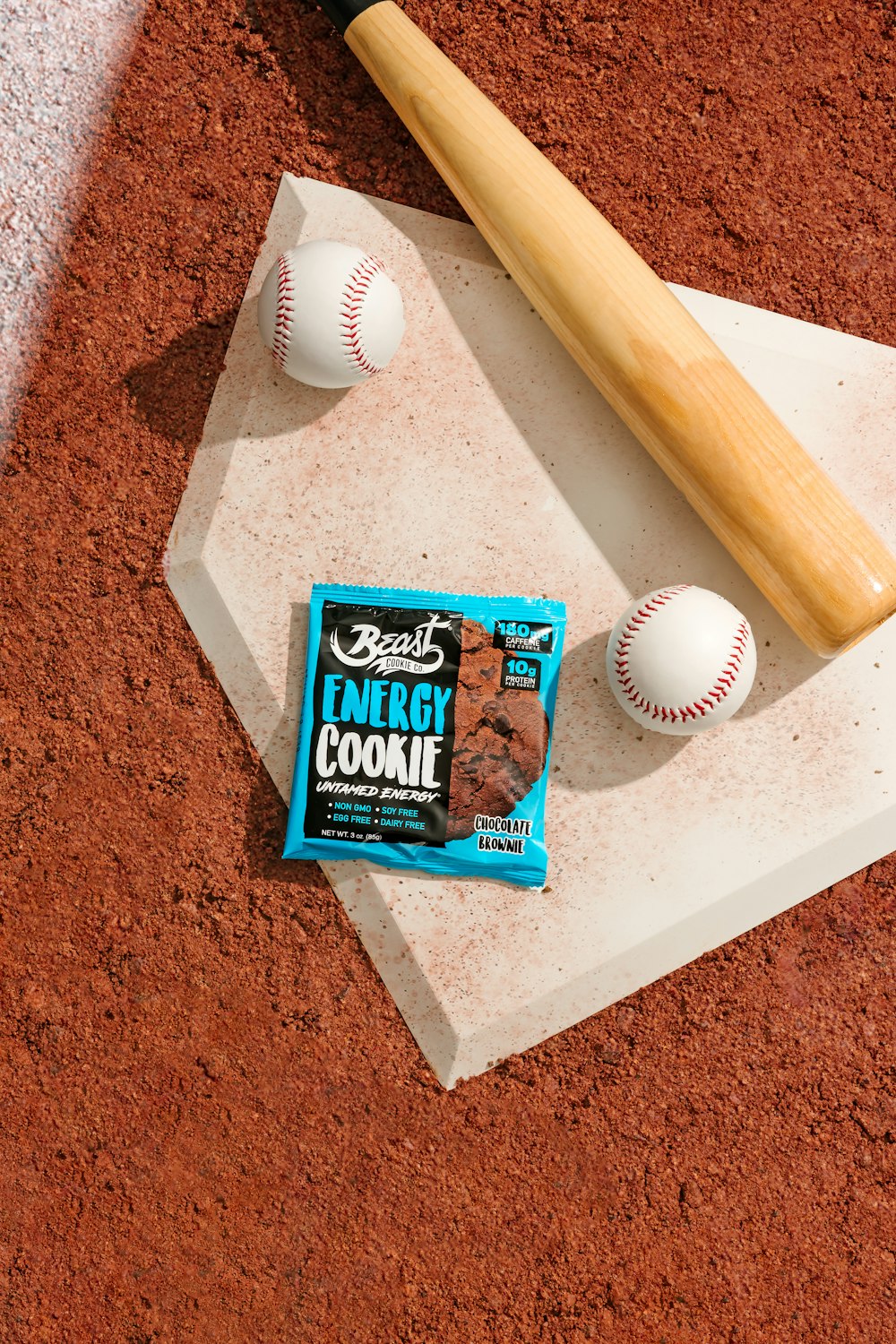 a baseball bat, candy bar, and a baseball on a baseball field