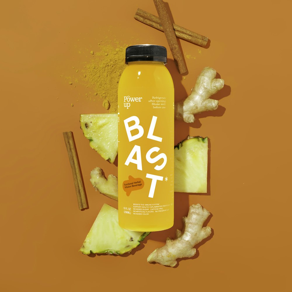 a bottle of blast juice surrounded by cut up fruit