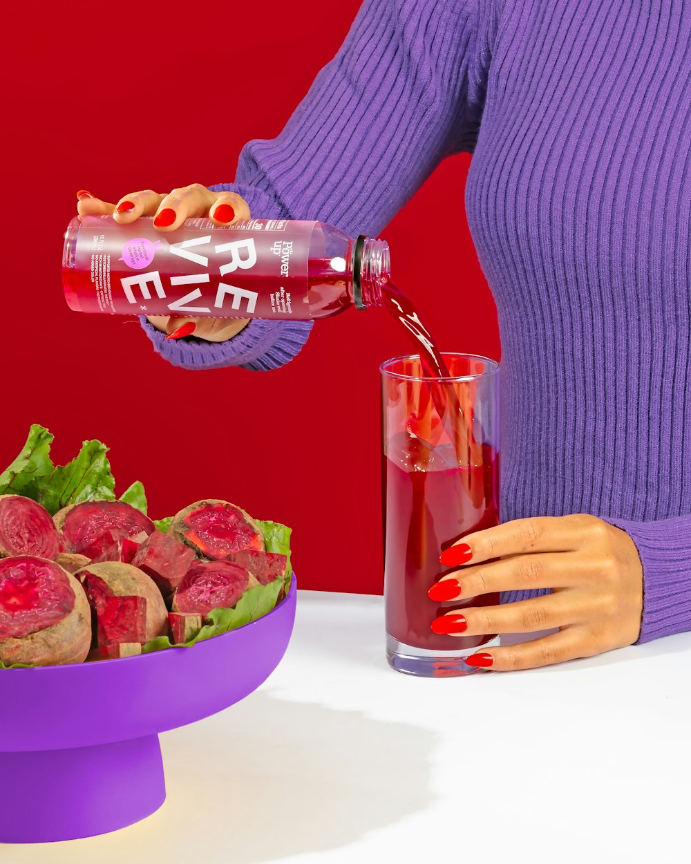 a woman pouring a drink into a bowl of food