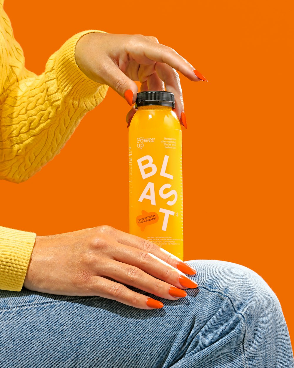a woman holding a bottle of orange juice