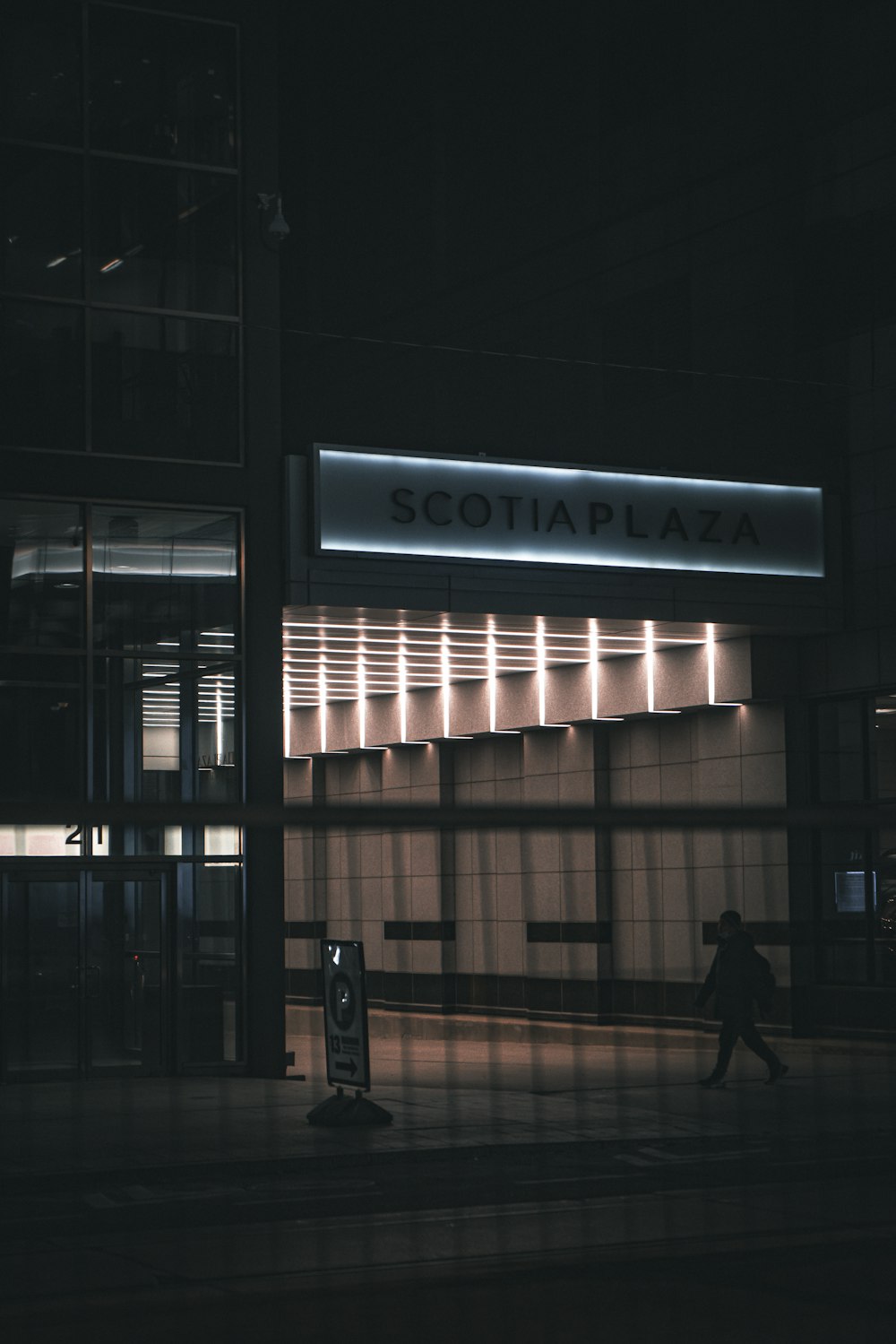 a person walking past a building at night