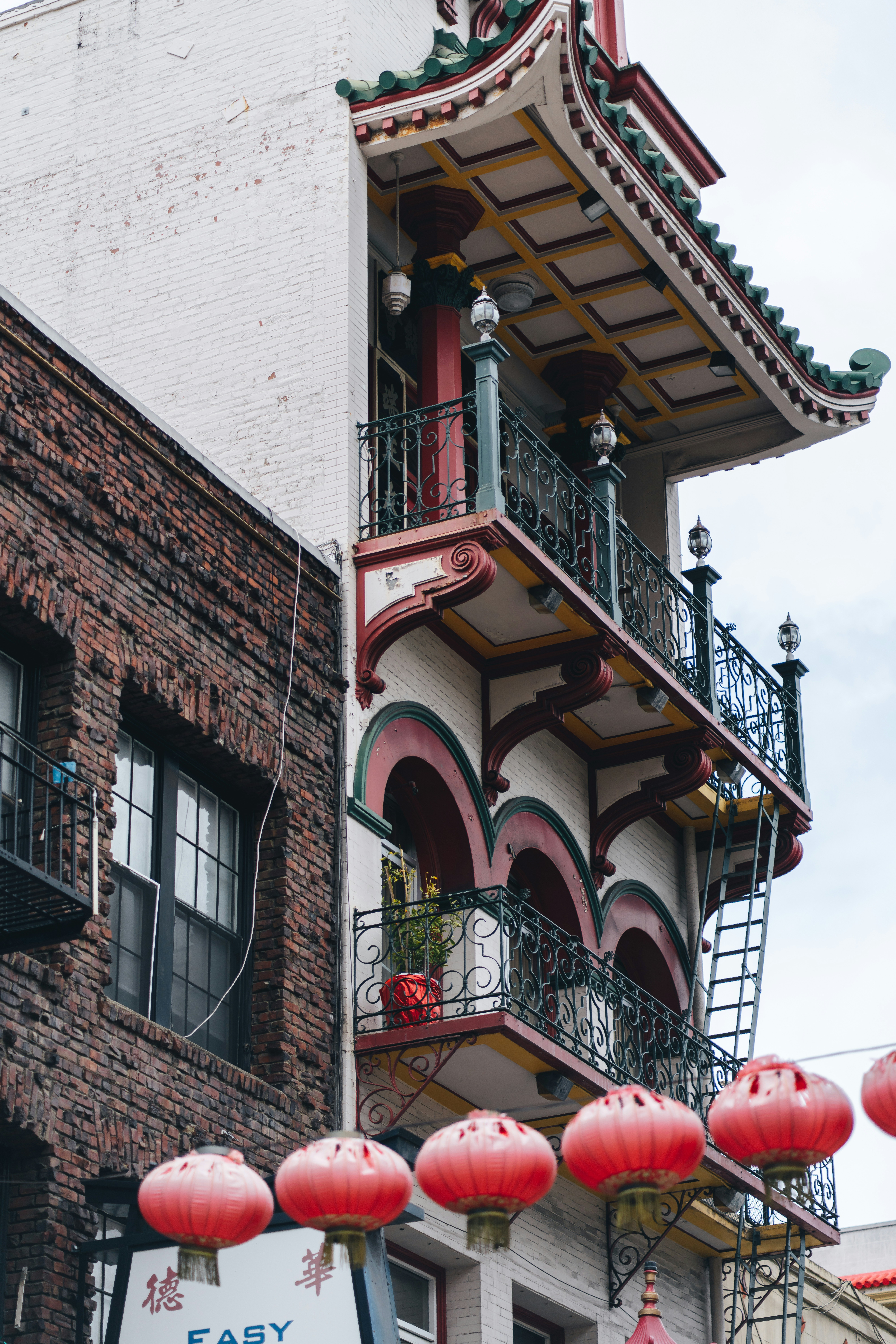 a tall building with red lanterns hanging from it's sides