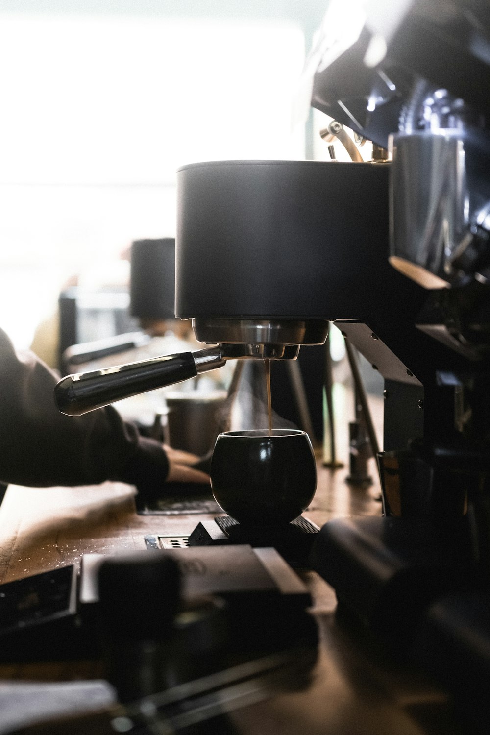 a person is using a coffee maker on a table