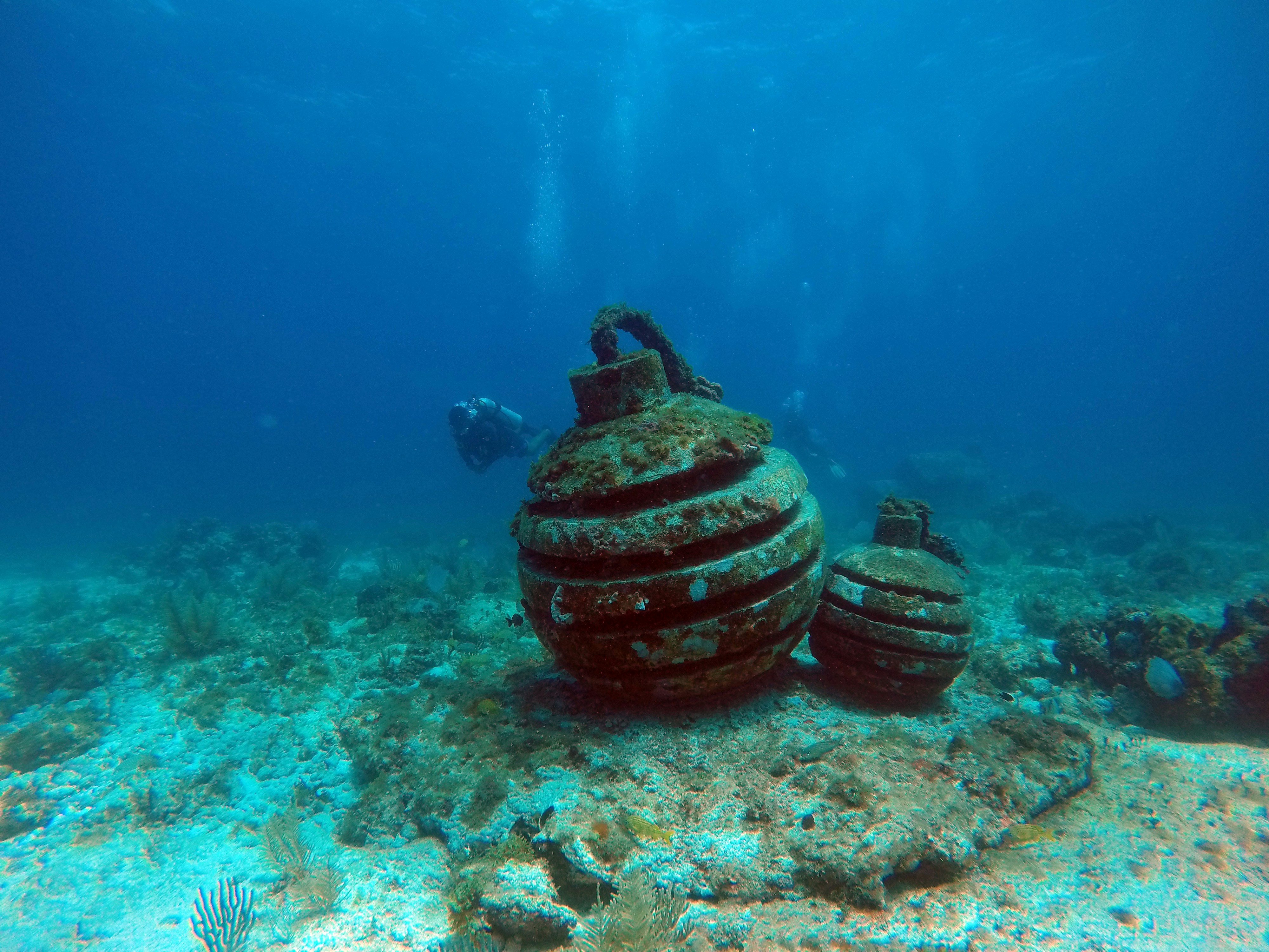 a man swimming in the ocean next to a large object