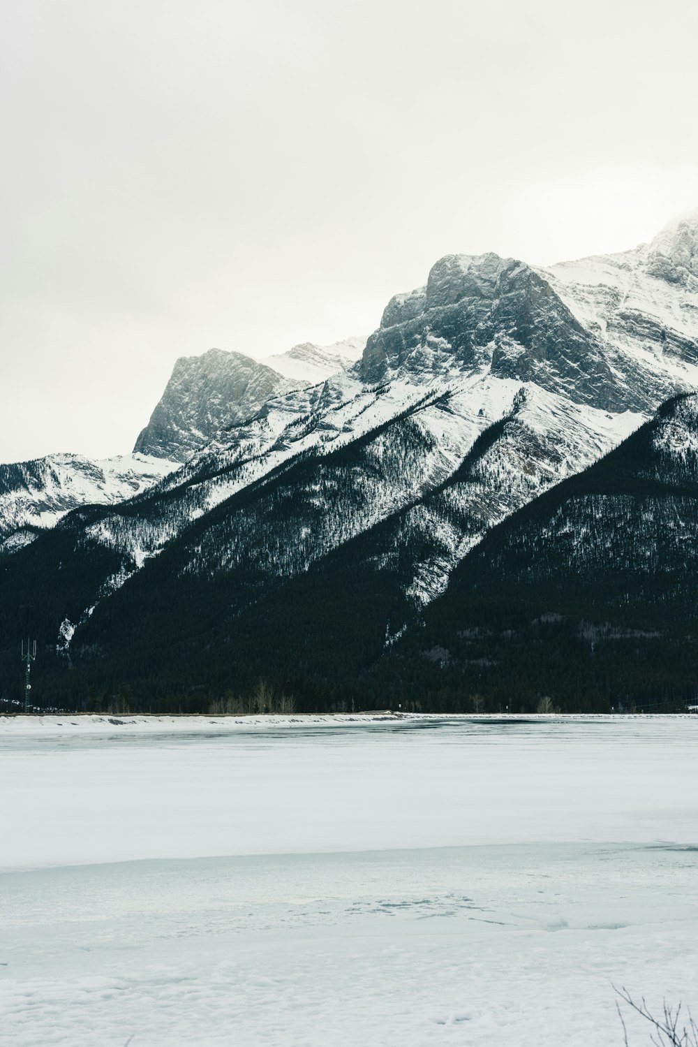 una cadena montañosa cubierta de nieve con un lago en primer plano