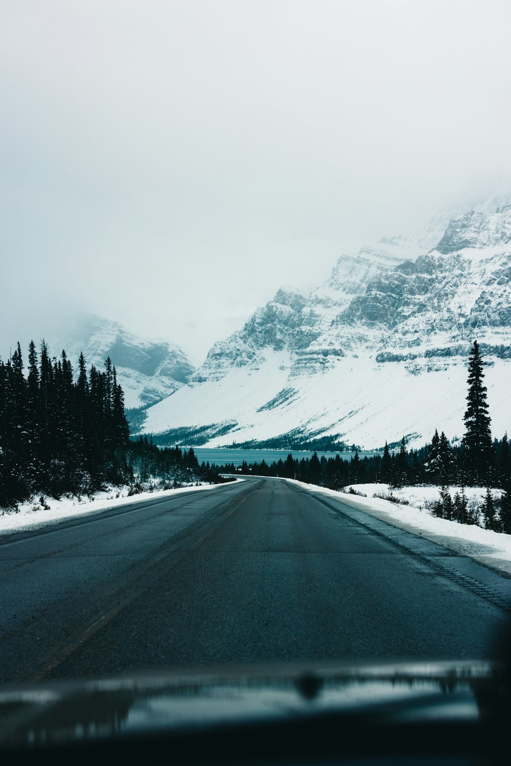 a car driving down a road in the snow