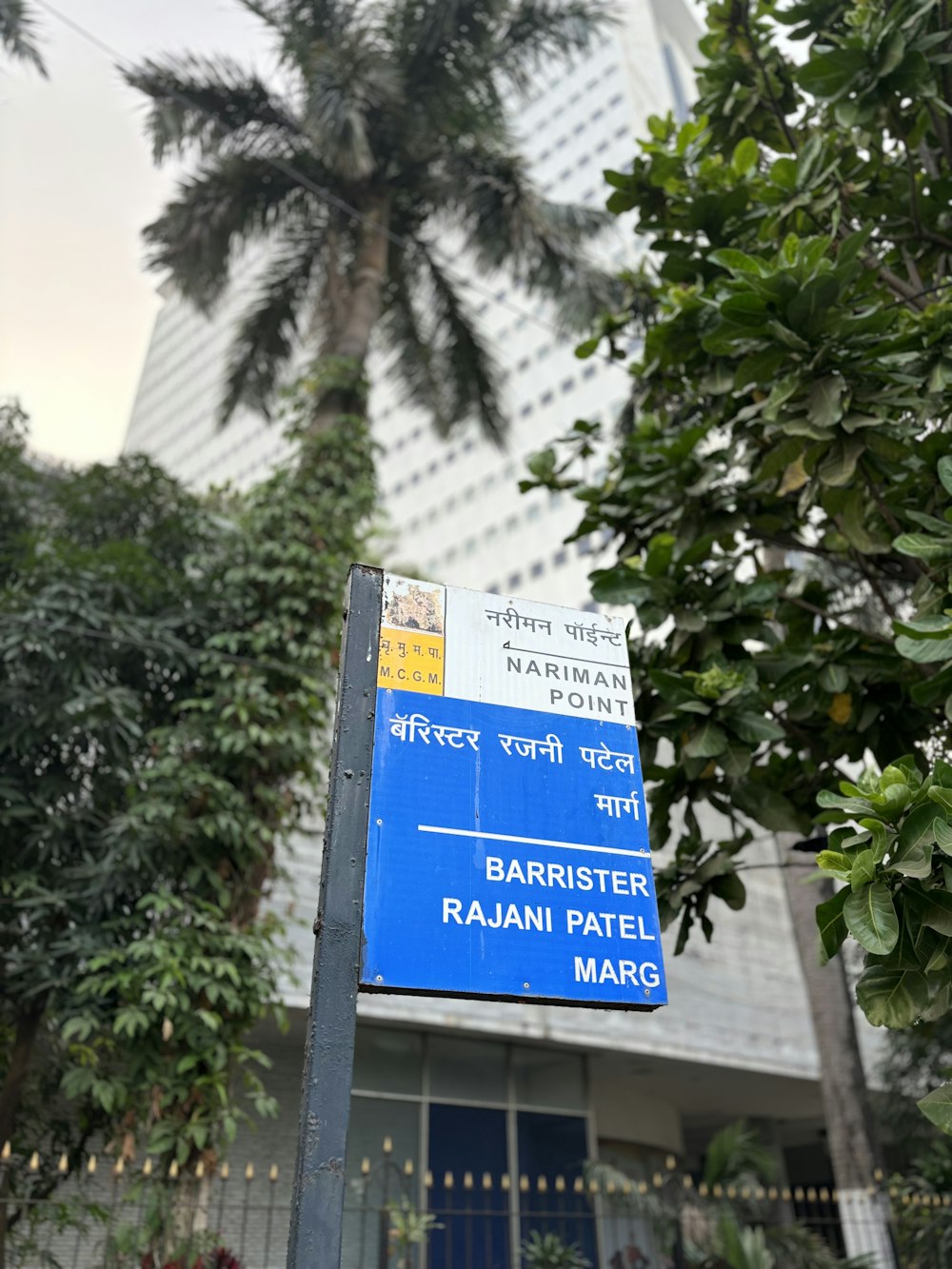 un cartello stradale blu seduto di fronte a un edificio alto