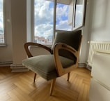 a chair sitting on a hard wood floor in front of a window