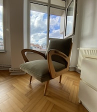 a chair sitting on a hard wood floor in front of a window