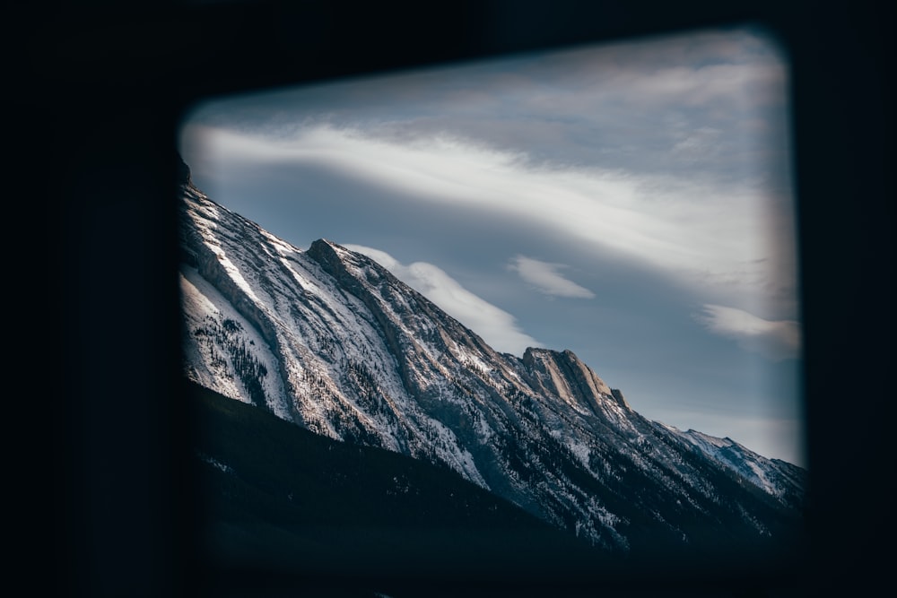 a view of a snow covered mountain through a window