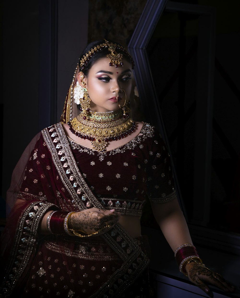 a woman in a red and gold bridal outfit