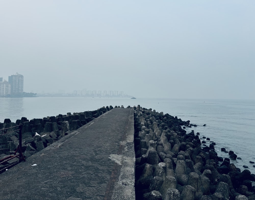 a long stone wall next to a body of water