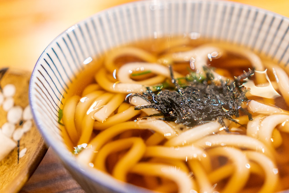 a bowl of soup with noodles and seaweed