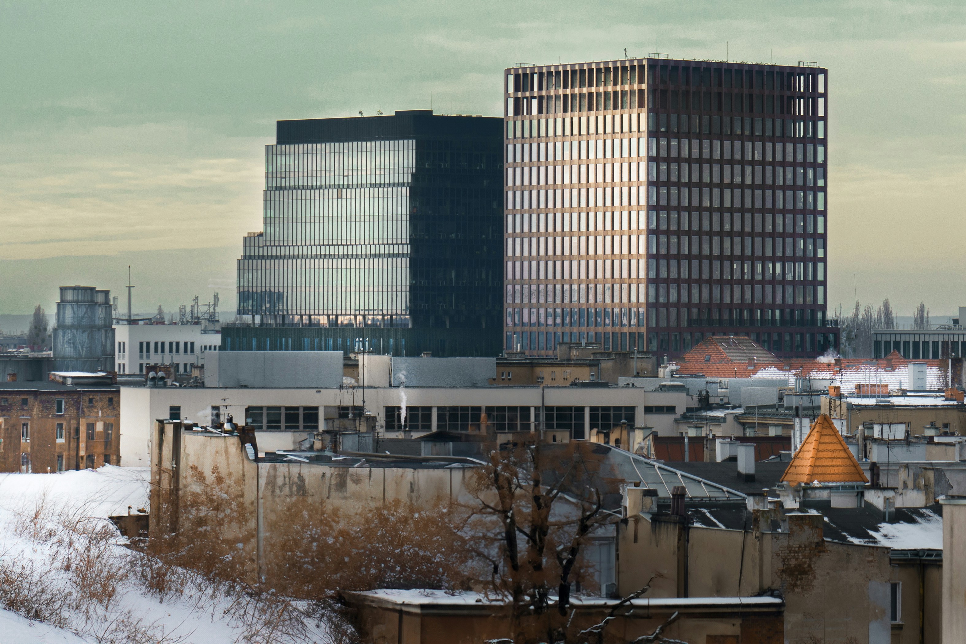 a view of a city with tall buildings in the background, City panorama. Modern architecture over old tenement houses.