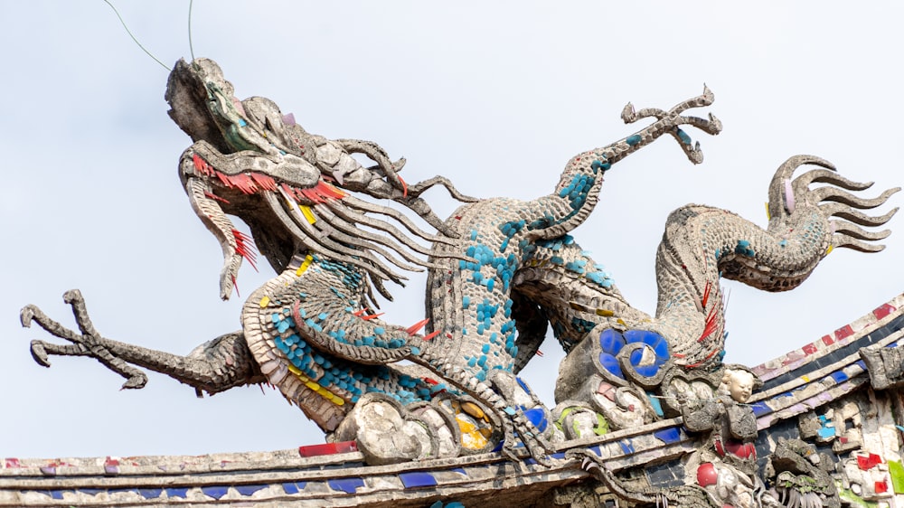 uma estátua de um dragão no topo de um edifício