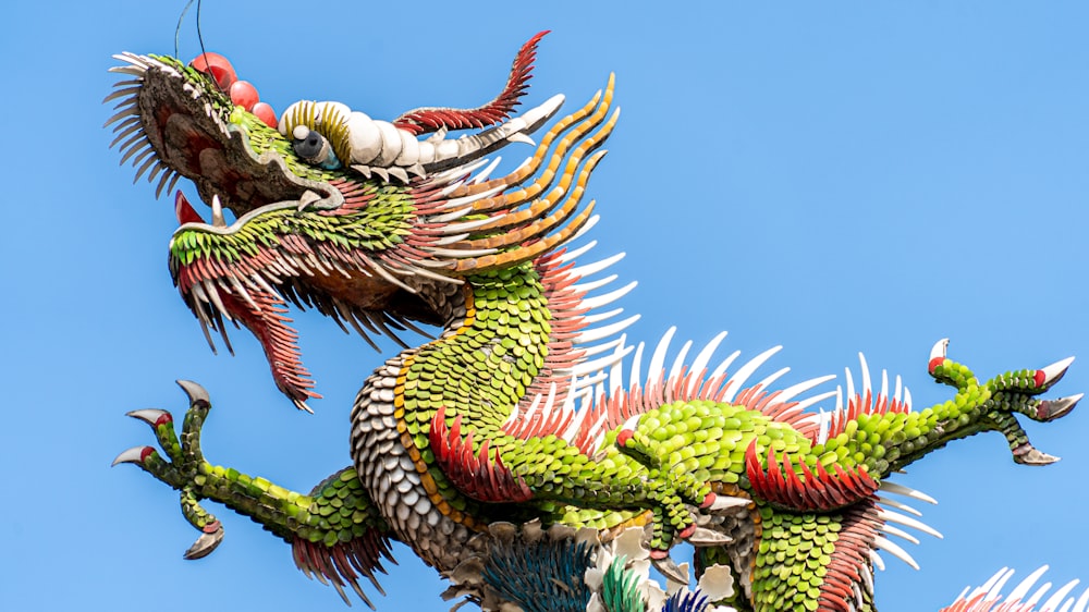uma estátua verde do dragão no topo de um edifício
