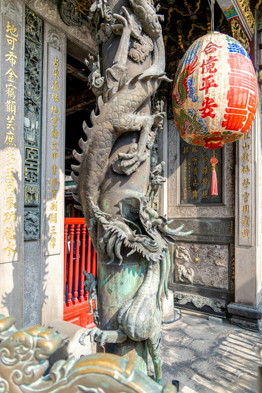 a statue of a dragon holding a ball in front of a building