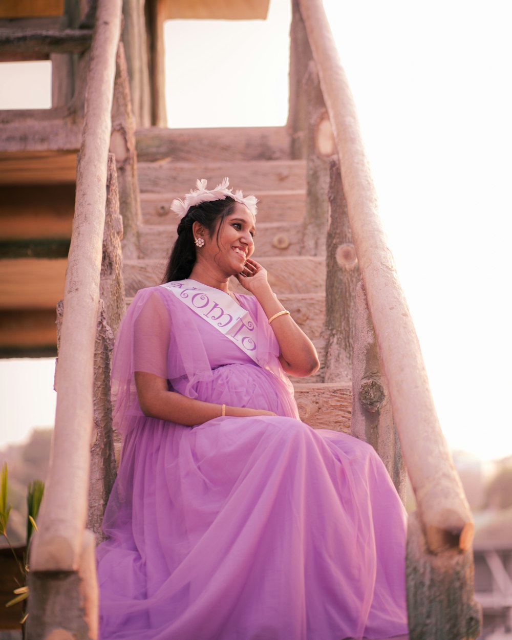 a woman in a purple dress sitting on a set of stairs