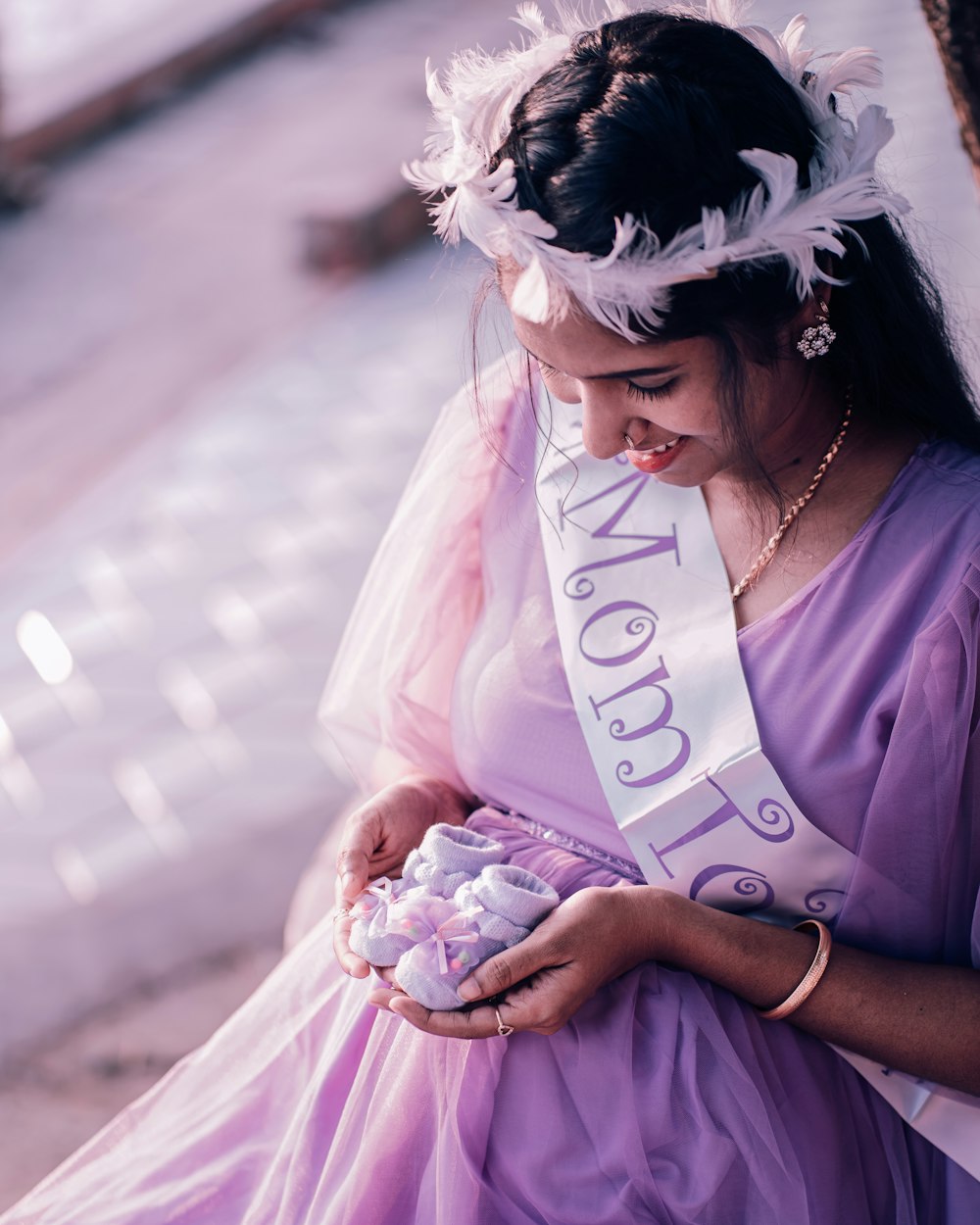 a woman in a purple dress holding a bouquet of flowers