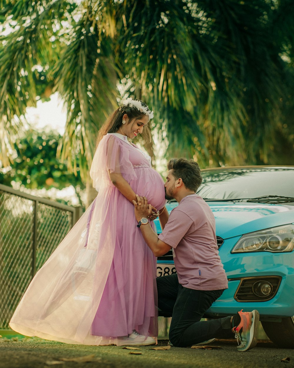 a man kneeling down next to a pregnant woman