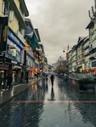 a group of people walking down a street holding umbrellas