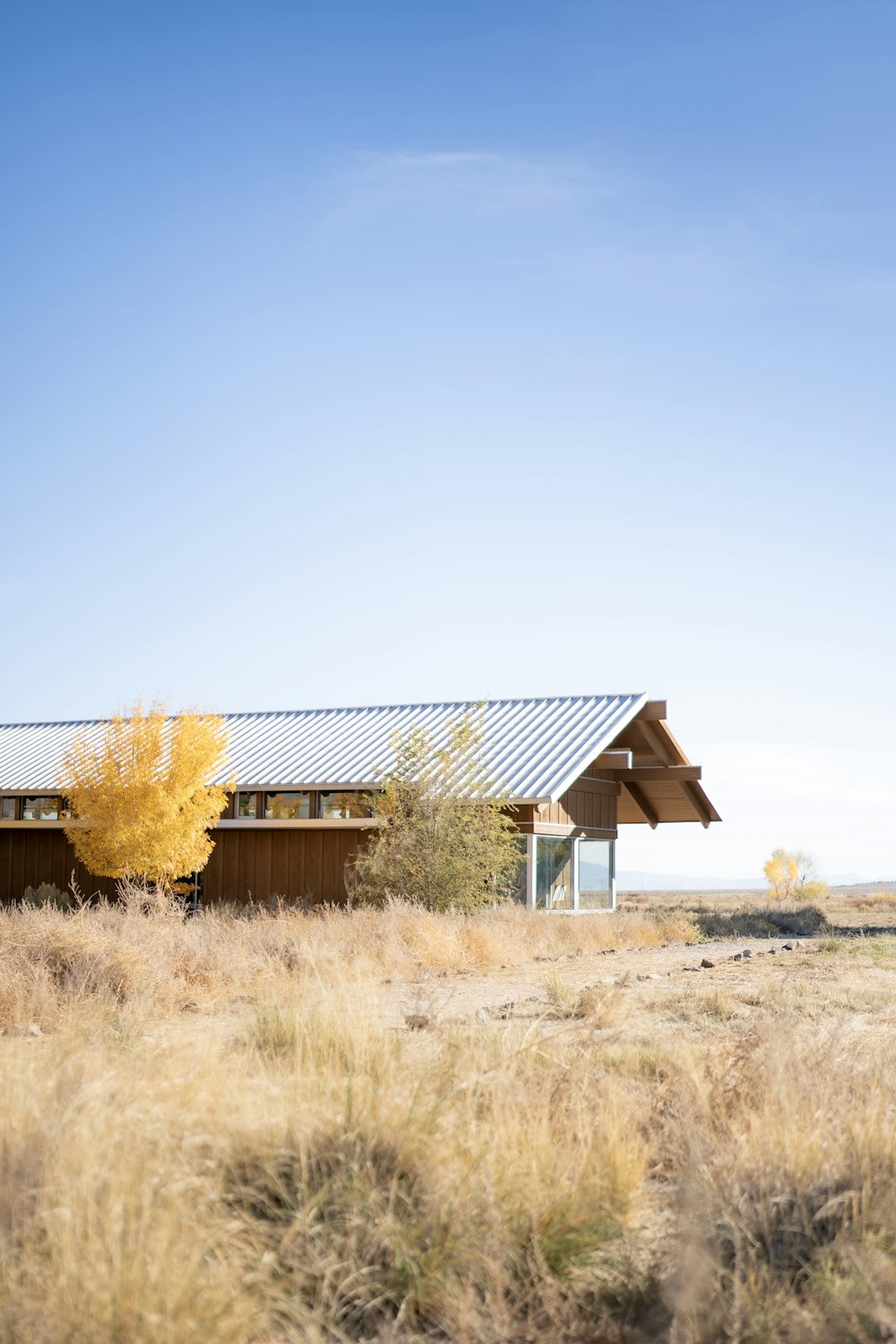 a house in the middle of a dry grass field