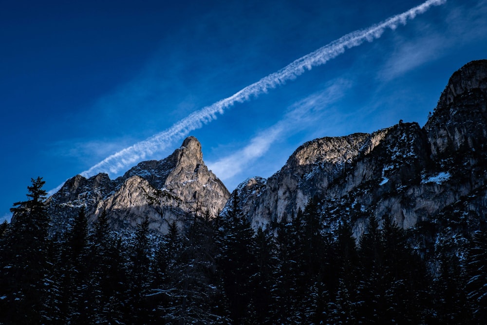 a view of a mountain range with a contrail in the sky