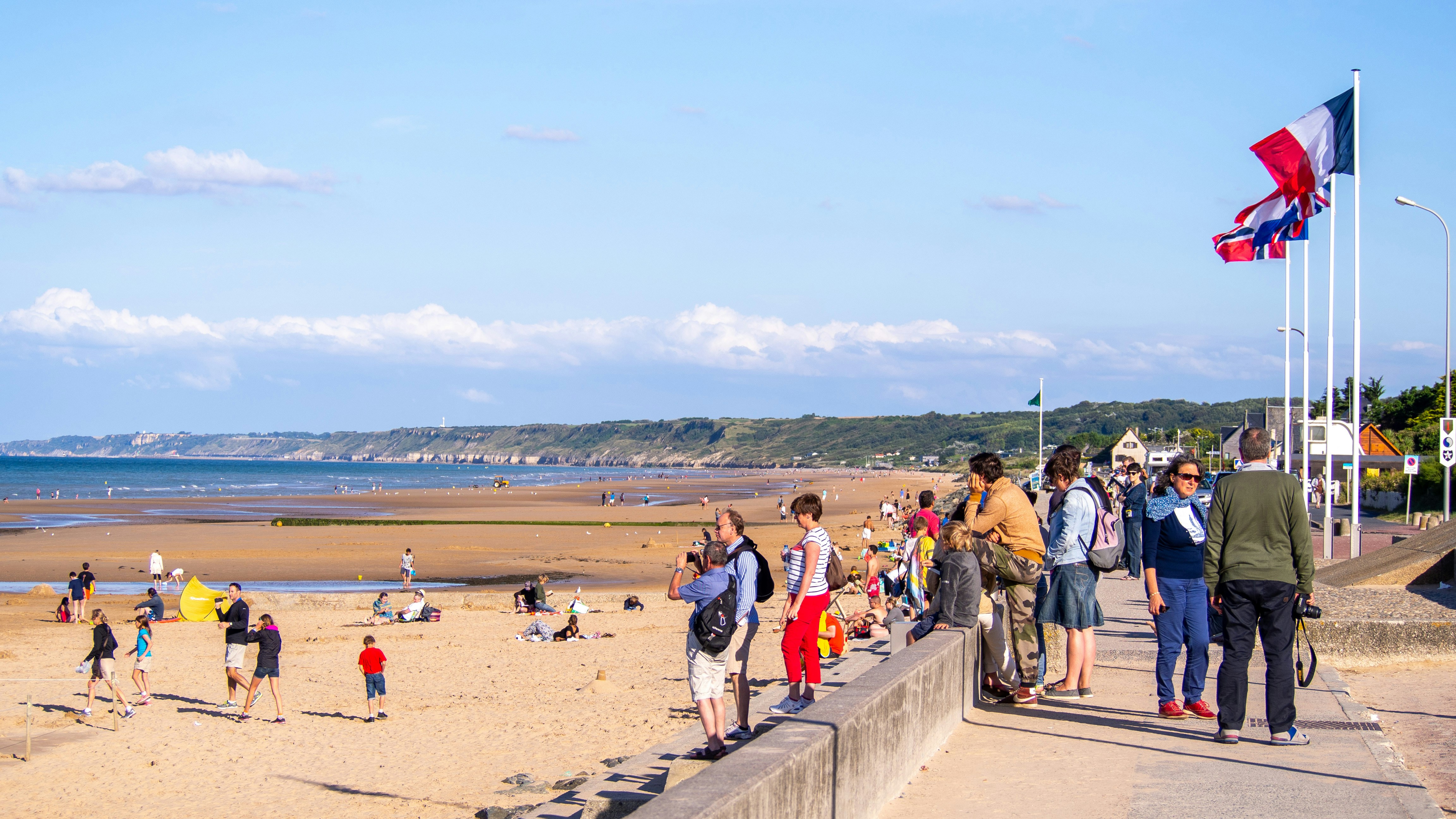 a group of people standing on top of a sandy beach