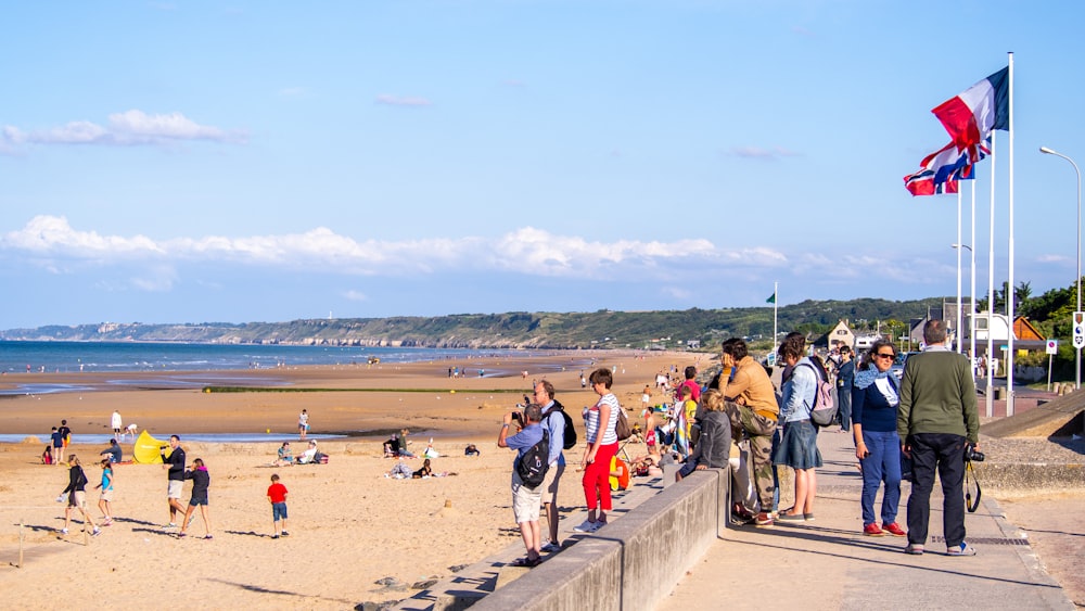 a group of people standing on top of a sandy beach