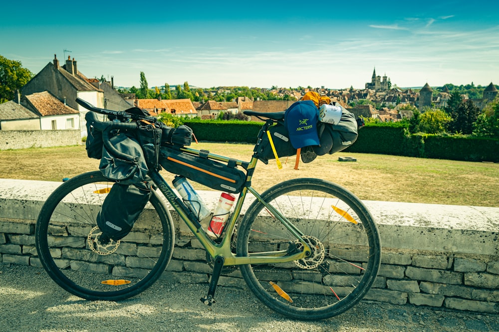 a bicycle parked next to a stone wall