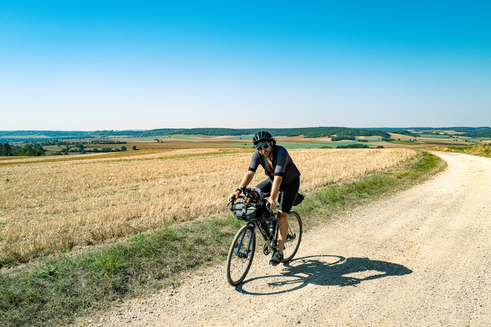 a man riding a bike down a dirt road