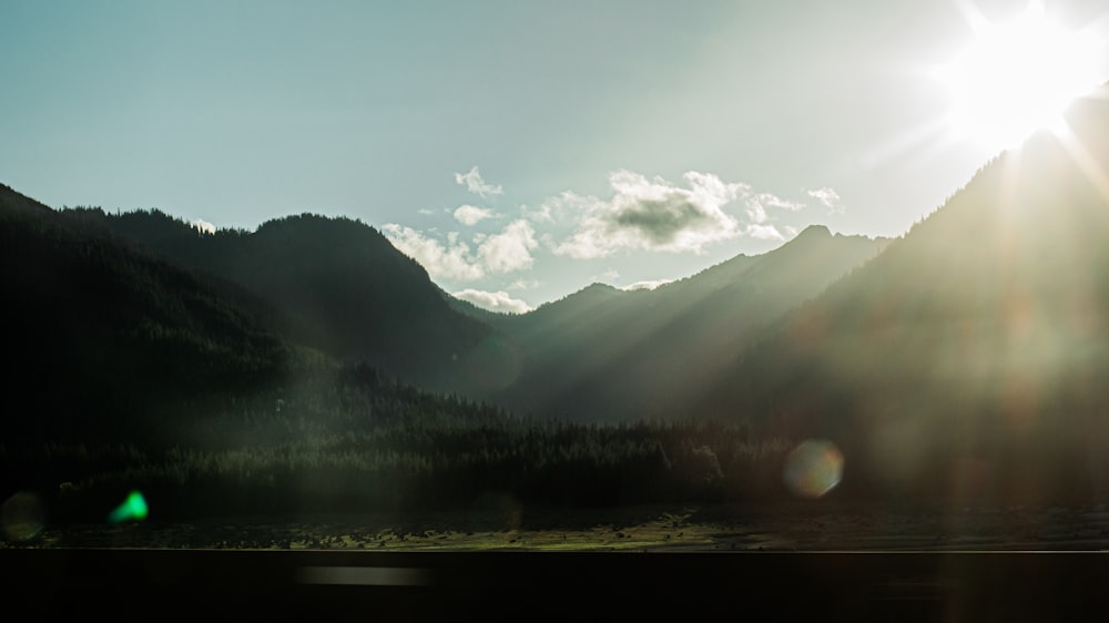 the sun shines brightly over a mountain range