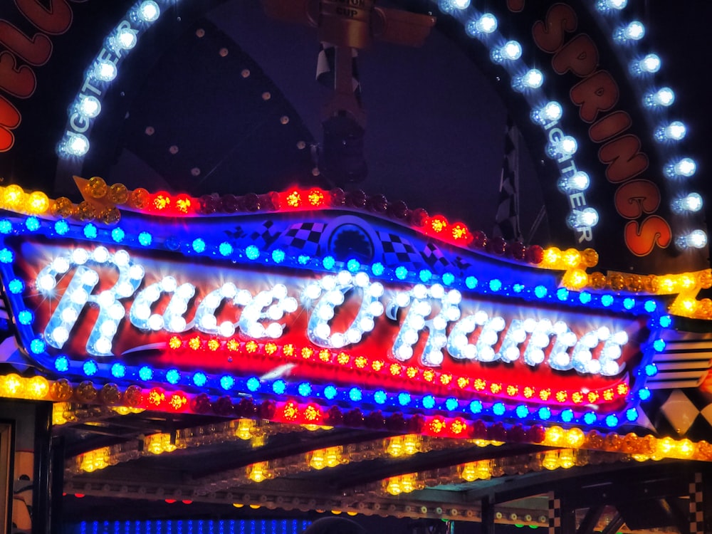 a carnival ride sign lit up at night