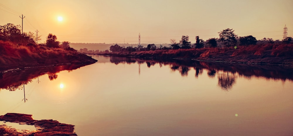 Die Sonne geht über dem Wasser eines Flusses unter