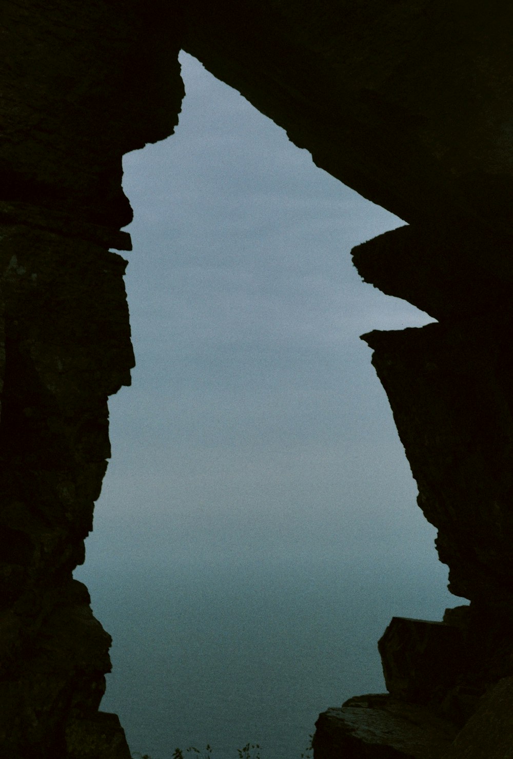 a view of a body of water through some rocks