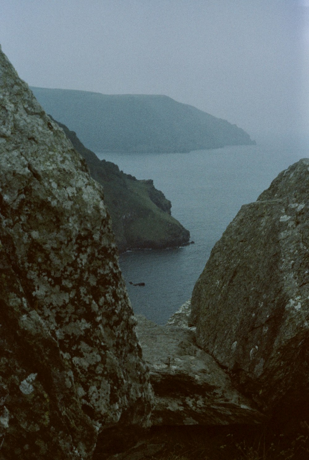 a couple of large rocks sitting next to a body of water