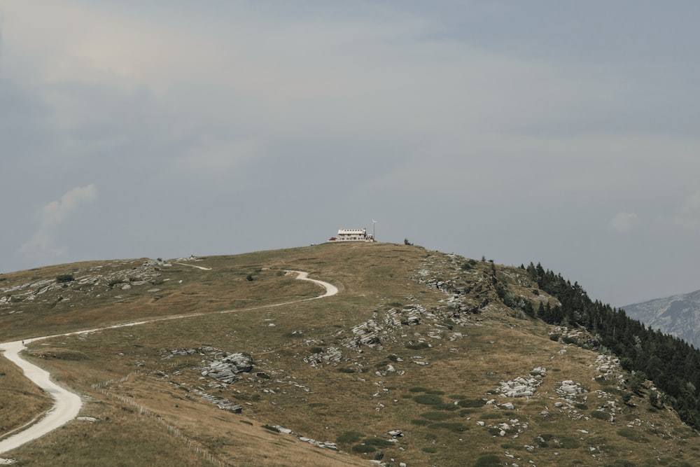 una strada che sale su una collina con una casa in cima