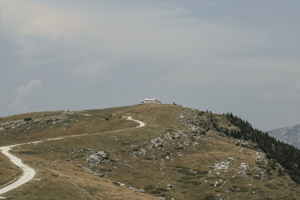 a road going up a hill with a house on top of it