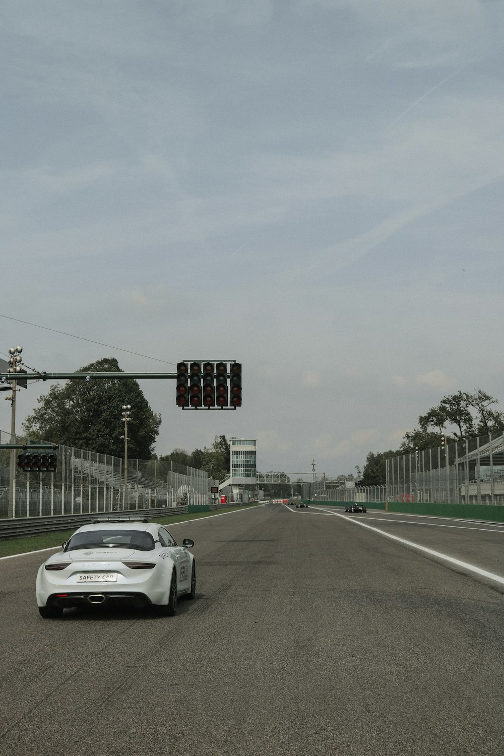 a white car driving down a street next to a traffic light