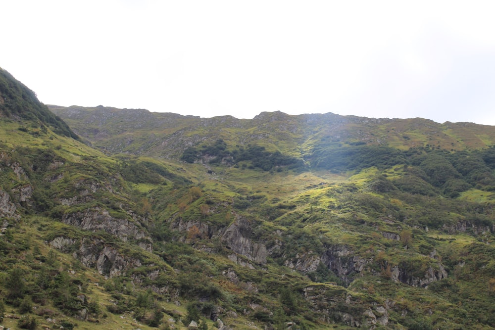 a view of a mountain side with a valley in the background