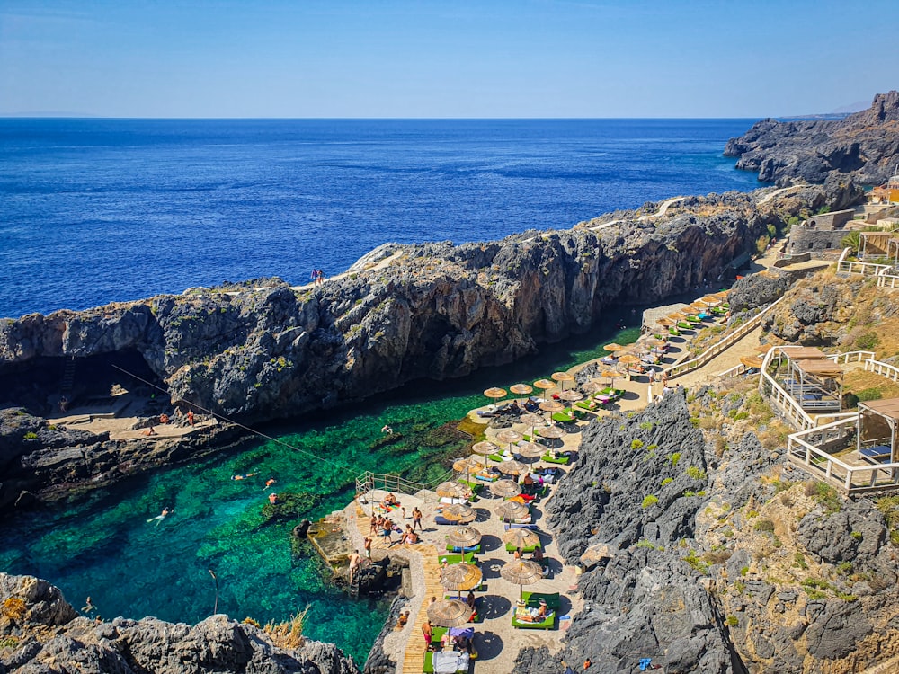 a rocky cliff overlooks the ocean and beach