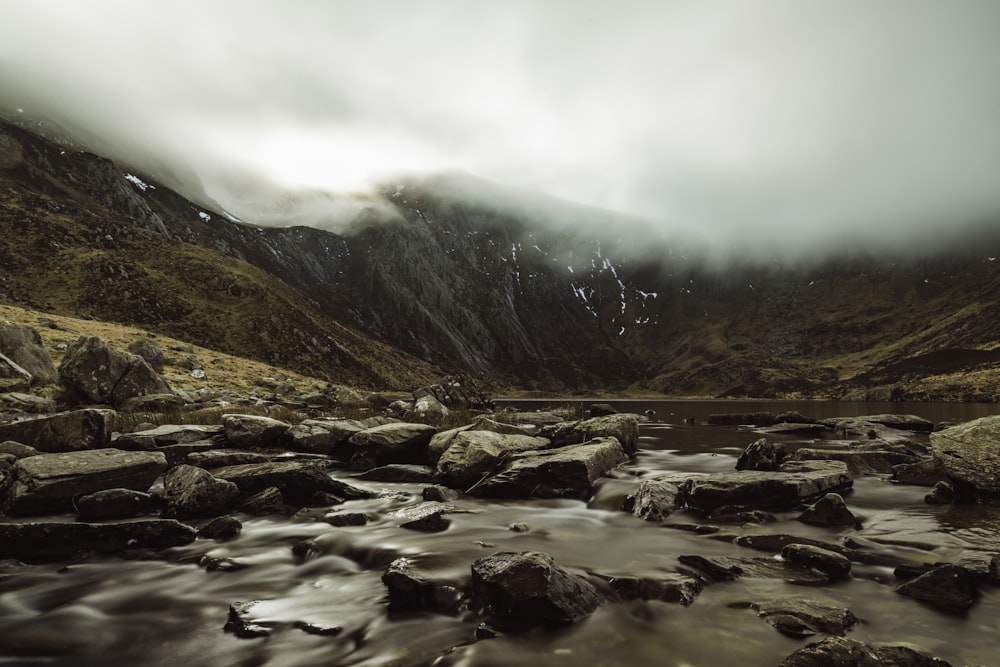 a river running through a valley surrounded by mountains